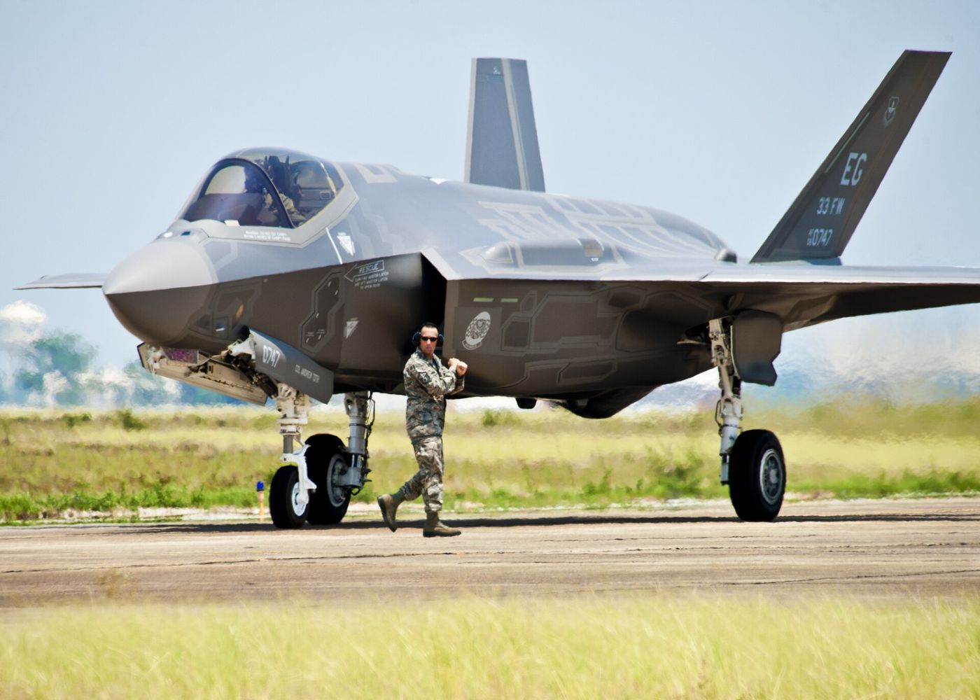 A 33rd Fighter Wing aircraft maintainer moves by the Department of Defense's newest aircraft, the U.S. Air Force F-35 Lightning II joint strike fighter…